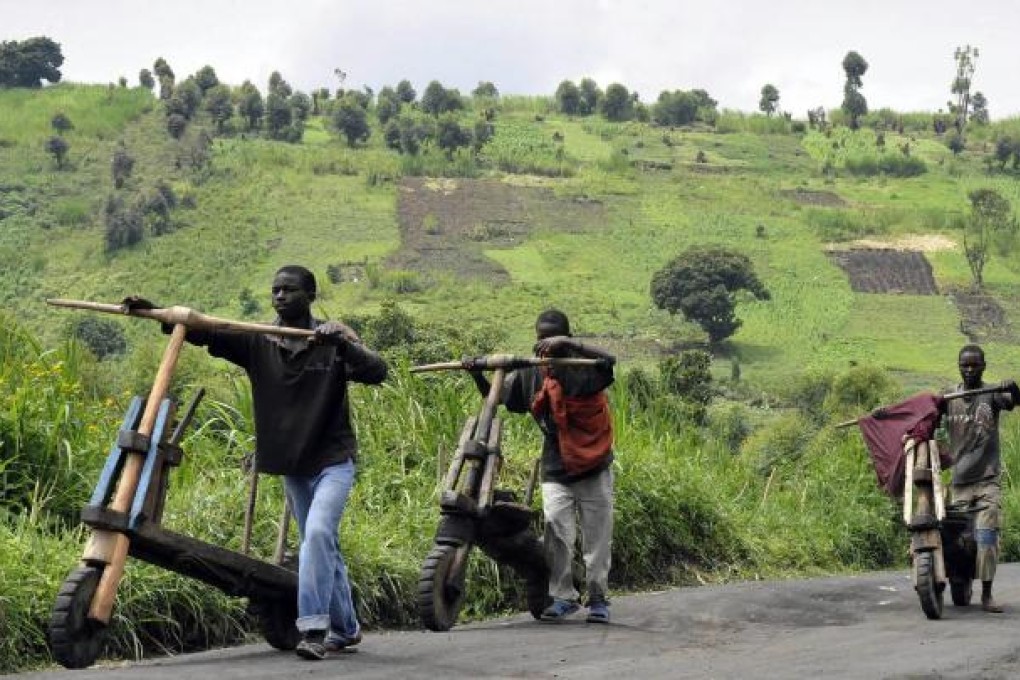 Three Congolese boys push their wooden bicycles, or chikudus, in North Kivu province. Production of the bicycles is an important part of the local economy. Photo: AFP