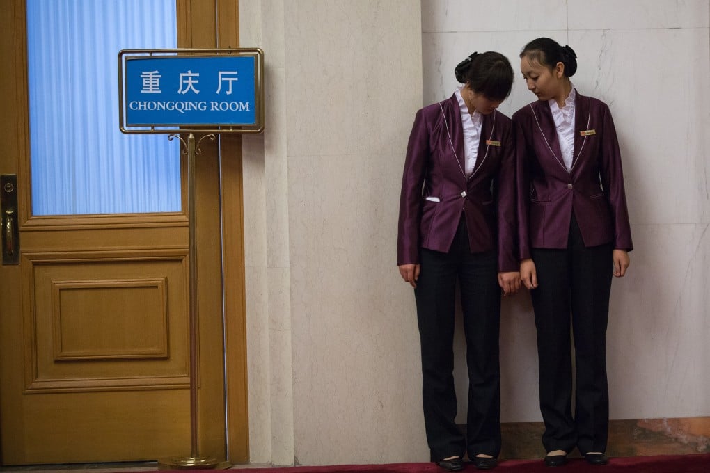 Two service staff stand outside the Chongqing room at the Great Hall of the People in Beijing during the 18th Communist Party Congress on Nov. 8, 2012. Photo: AP