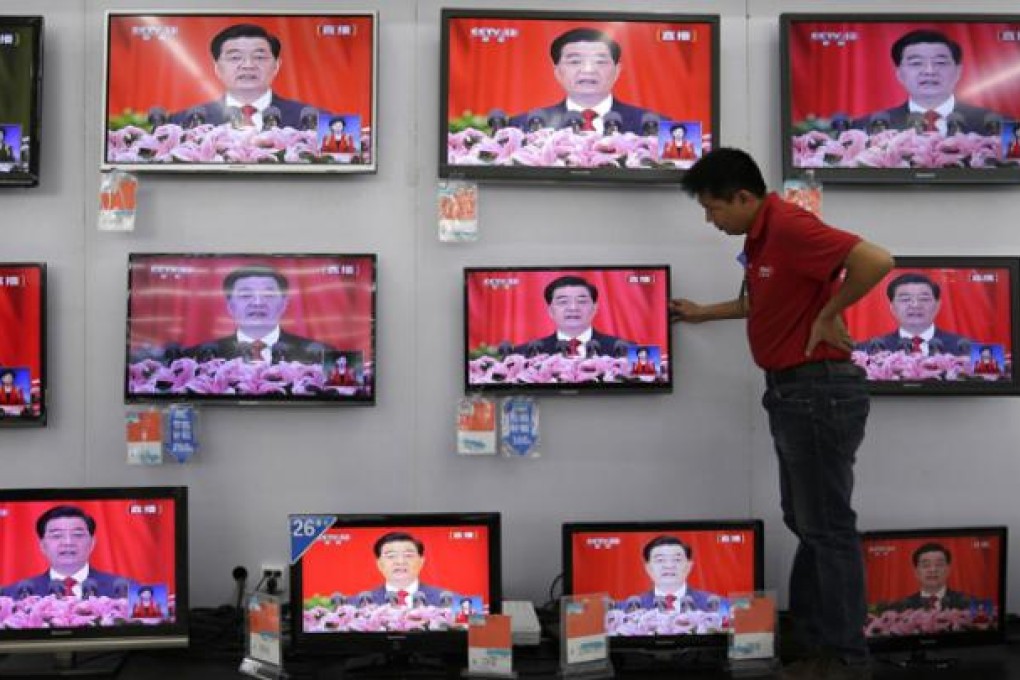 A man adjusts a television screen showing a live broadcast of Chinese president Hu Jintao speaking at the opening of the 18th Communist Party Congress. Photo: AFP