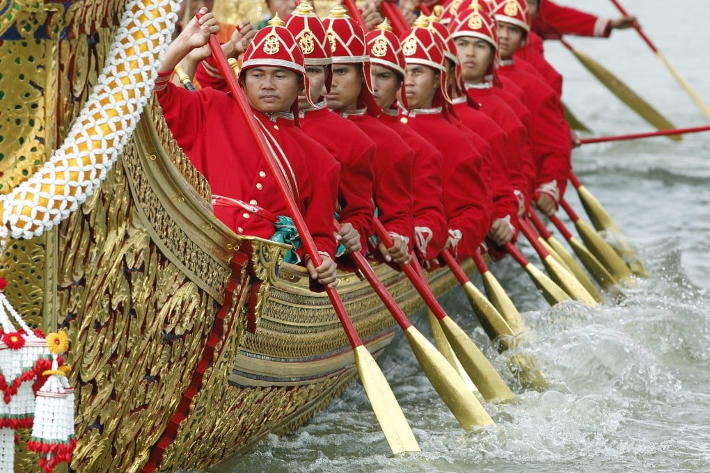 Thai Royal Navy oarsmen in ancient warrior costumes row in the royal barge procession on the Chao Phraya River in Bangkok on Friday. Photo: EPA