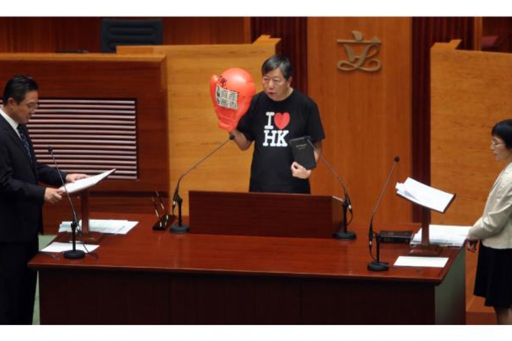 Lawmaker Lee Cheuk-yan (centre) takes an oath at Legislative Council in Tamar wearing a boxing glove to protest against old-age allowance means test.