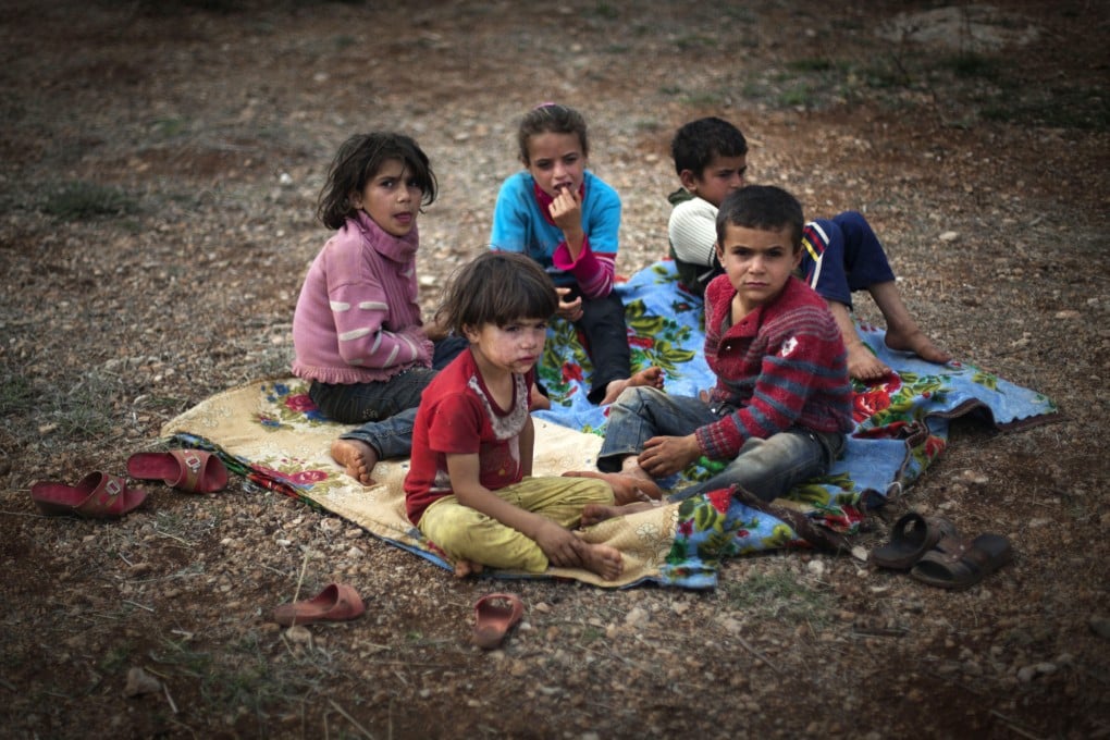 Syrian children, who fled with their families from violence in their village, sit on the ground at a refugee camp in Atmeh, near the Turkish border. Photo: AP