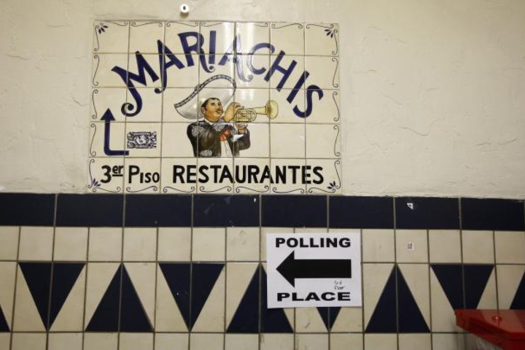 A directional sign points the way to a polling place inside El Mercado de Los Angeles, a Mexico-style marketplace in the heavily Latino East L.A. area, during the U.S. presidential elections. Photo: AFP