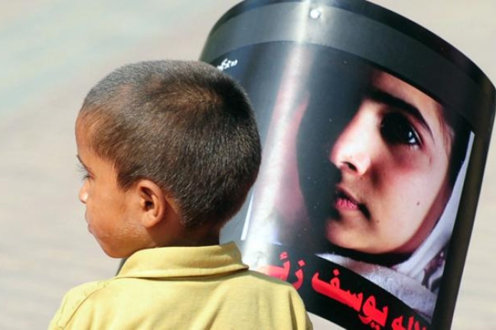 A Pakistani boy carries a photograph of child activist Malala Yousafzai to mark 'Malala Day' in Karachi on Saturday. Photo: AFP