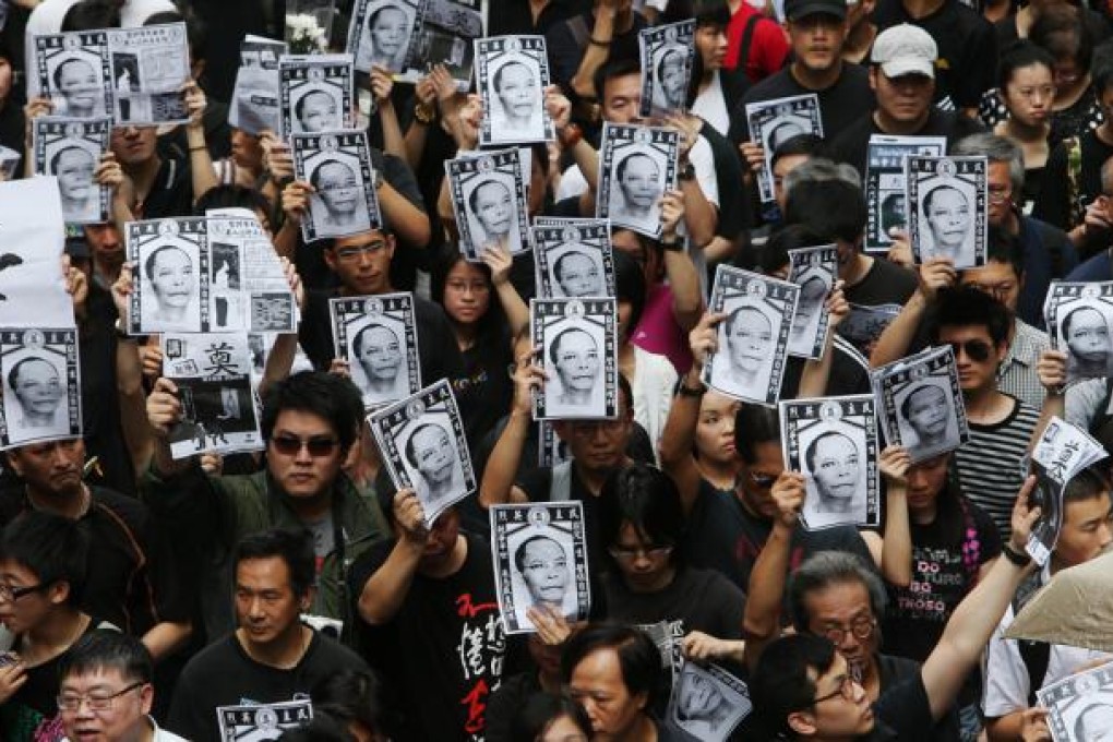 Thousands of protesters pack a down town street during a protest march to mourn for Chinese activist Li Wangyang's death.
