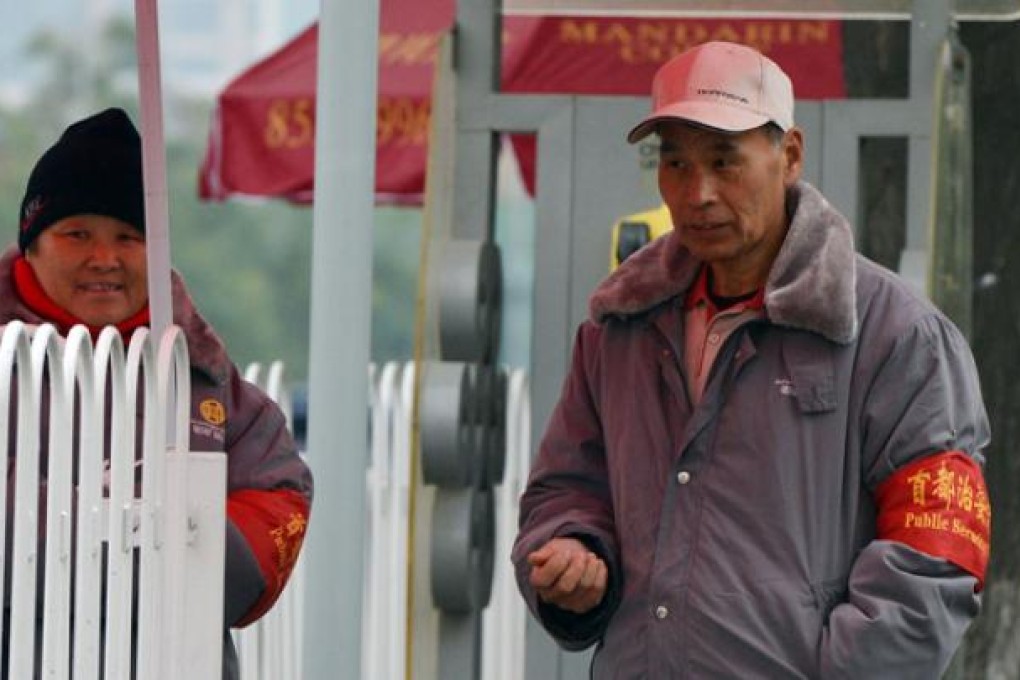 Security volunteers keep watch near the Great Hall of the People, which is the site of the 18th party congress in Beijing on Saturday. Photo: AFP