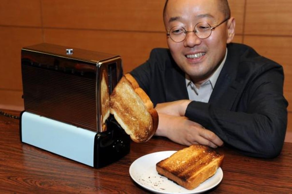 Kenichi Masuda with Toshiba's 'walking toaster'. Photo: AFP