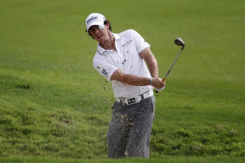 Rory McIlroy hits out of bunker on the first hole during the third round of the Barclays Singapore Open golf tournament.