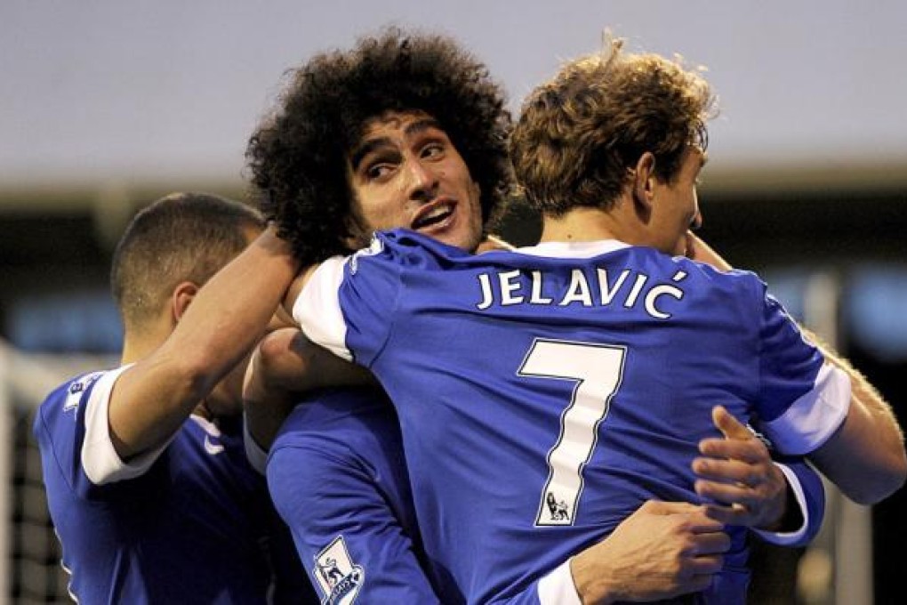 Everton's Marouane Fellaini, center, celebrates scoring against Fulham with teammate Nikica Jelavic during the English Premier League match at Craven Cottage.