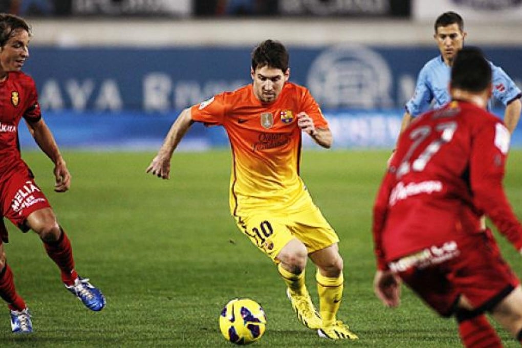 Barcelona's Lionel Messi drives the ball next to RCD Mallorca's Joaquín Navarro Ximo (right) and Tomás Pina. Photo: AP