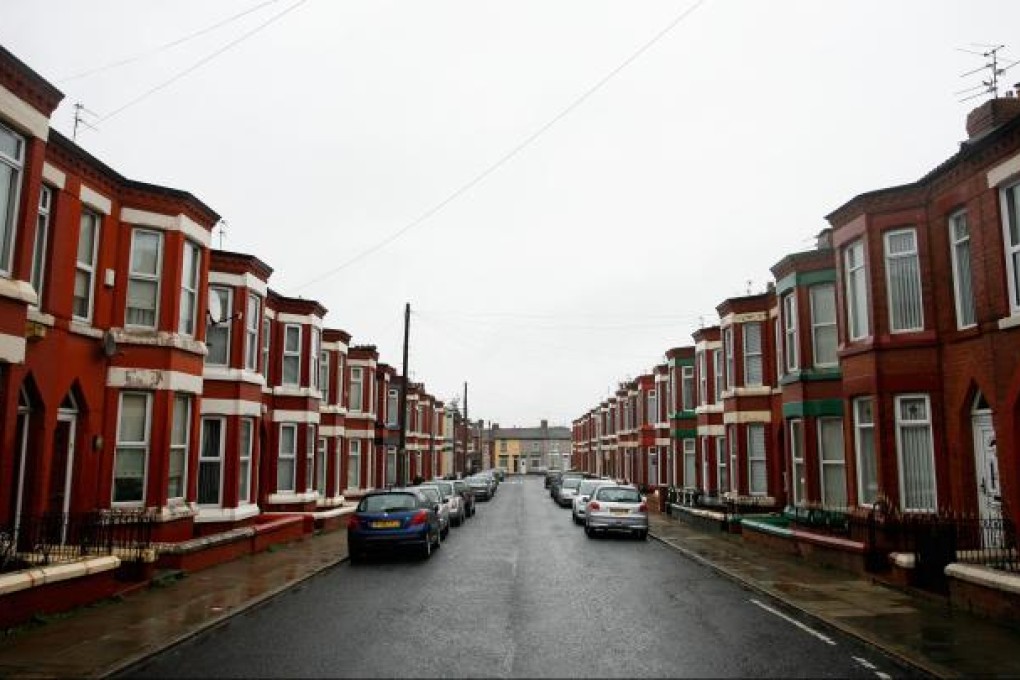 Vehicles sit parked outside a row of terraced houses in Liverpool, U.K., on Feb. 24, 2012. Photo: Bloomberg