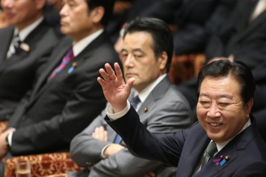 Yoshihiko Noda raises his hand to answer a question at a Diet budget committee session yesterday. Photo: AFP