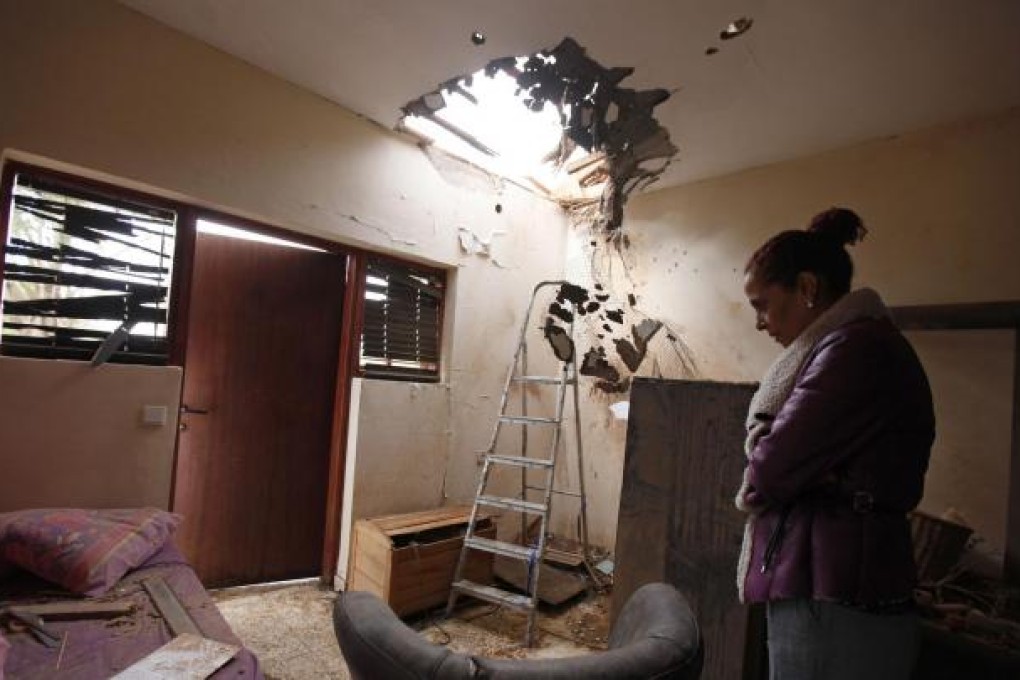 A Jewish woman surveys her damaged home in Sderot. Photo: Reuters
