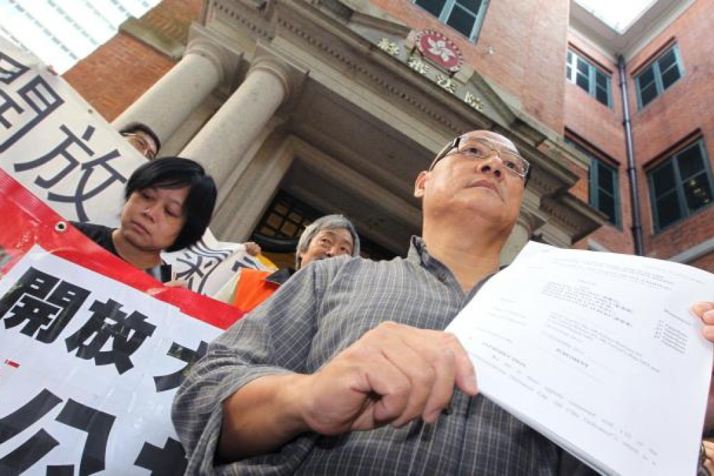 Flanked by supporters, lawmaker Albert Chan holds a copy of the judgment ruling against his conviction for speaking on an unlicensed radio station. Photo: Felix Wong