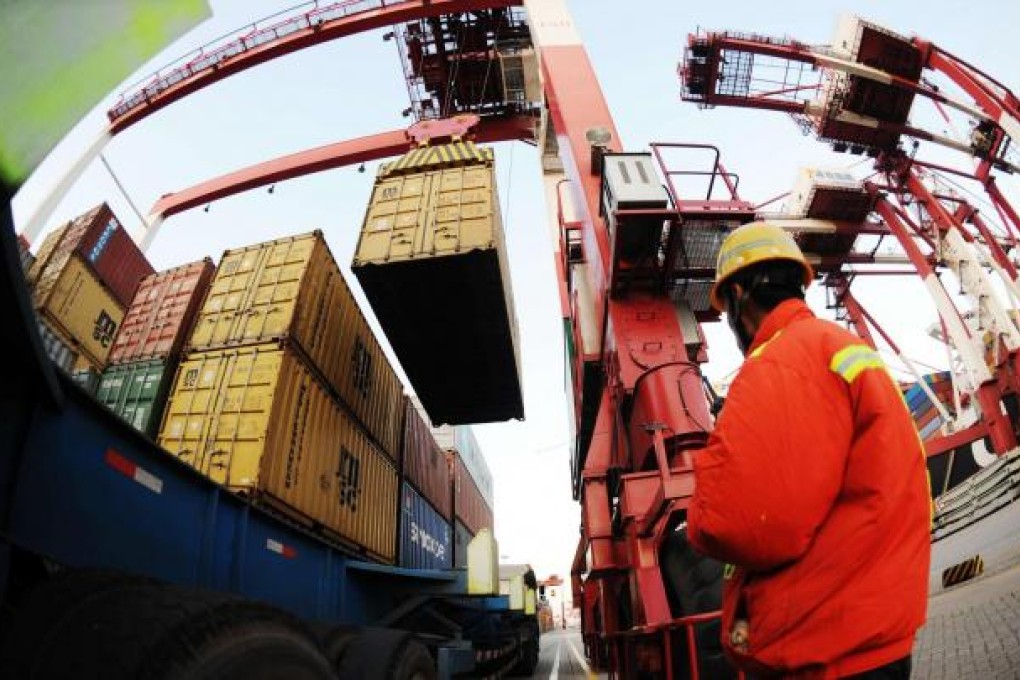 A worker monitors containers at Qingdao port. Analysts expect full-year new lending by banks to stabilise by the end of the year. Photo: AFP