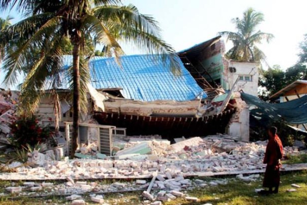 A Buddhist monk looks at a damaged house in Tabaitgine township in Mandalay region on Monday. Photo: Xinhua