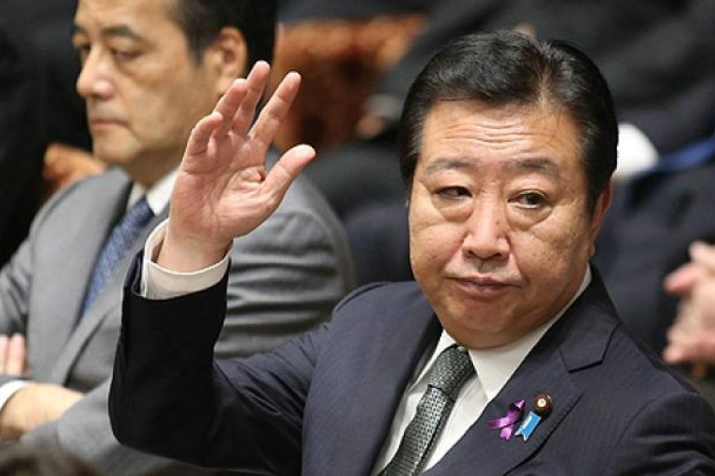 Japanese Prime Minister Yoshihiko Noda raises his hand to answer a question at the Lower House's budget committee session on Tuesday. Photo: AFP