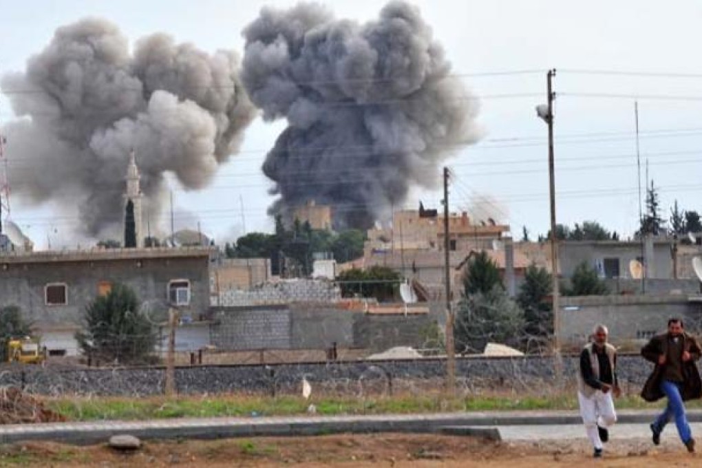 People run for cover after a Syrian aircraft bombed the strategic border town of Ras al-Ain on Tuesday. Photo: AFP