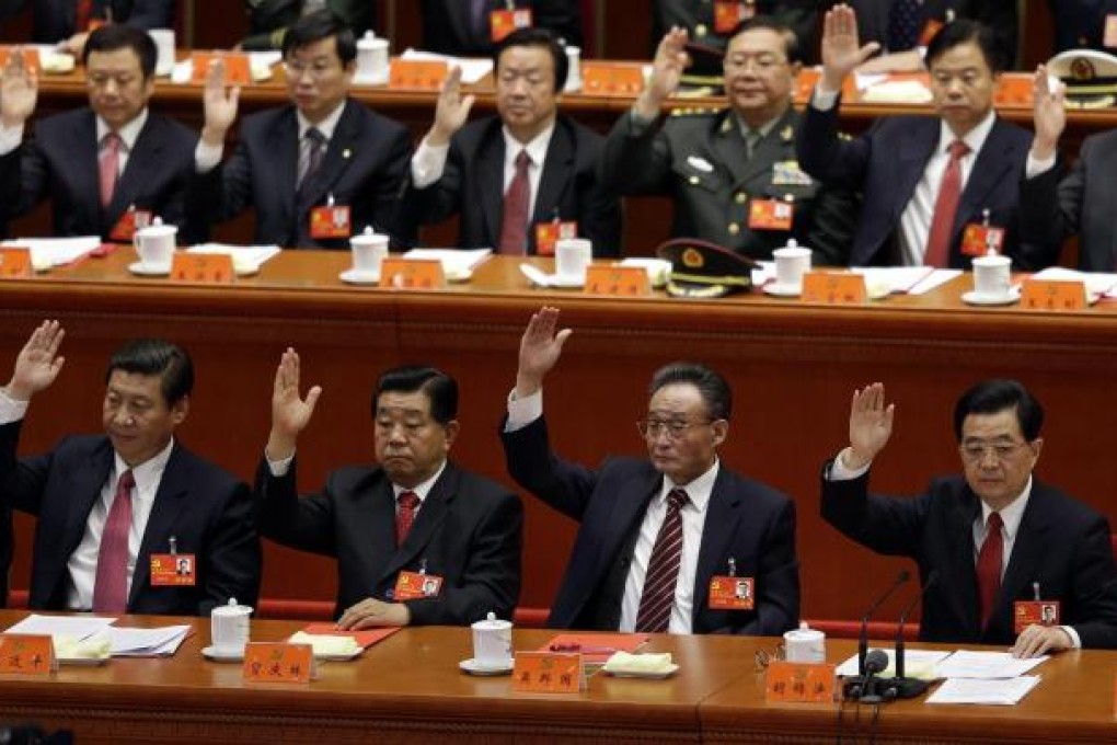 China's top leaders past and present, senior politicians and their advisors raise their hands as they take a vote at the closing session of the National Congress. Photo: Reuters