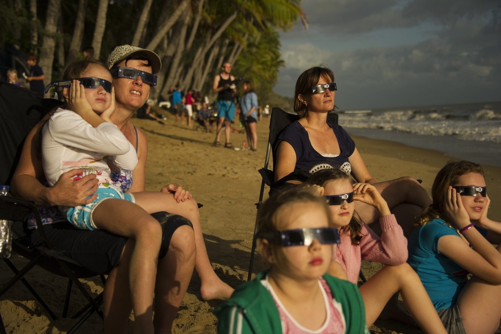 Families watch a total solar eclipse from Ellis Beach, north of Cairns in far north Queensland, Australia, on Wednesday. Photo: EPA