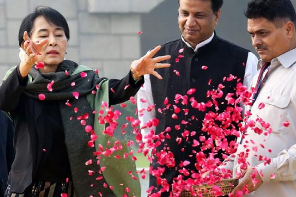 Myanmar opposition leader Aung San Suu Kyi sprinkles petals as she pays tribute at the Mahatma Gandhi memorial at Rajghat in New Delhi on Wednesday. Photo: EPA