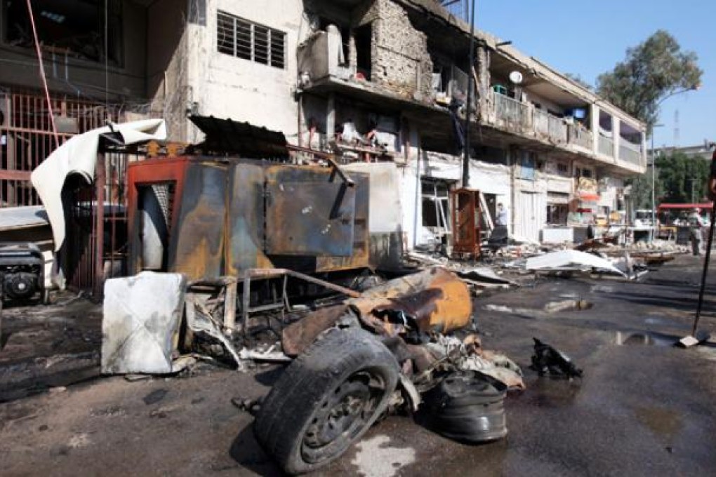 Damaged shops and cars are seen at the scene of a car bomb attack in Baghdad, on Wednesday. Photo: EPA