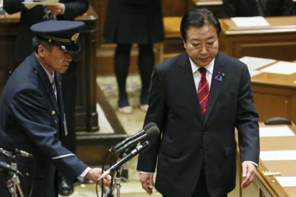Japanese Prime Minister Yoshihiko Noda (right) is escorted by a parliamentary guard to a room for a debate at Japan's Lower House in Tokyo on Wednesday. Photo: EPA