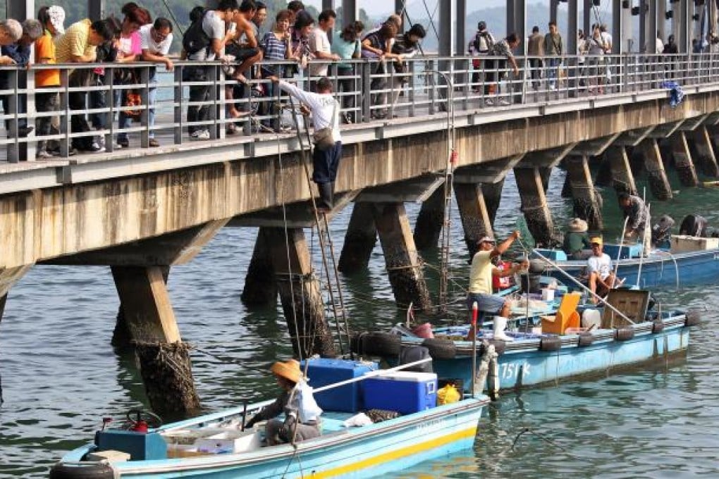 Locals buying fish from sampans tied up at Sai Kung pier. Photo: Dickson Lee