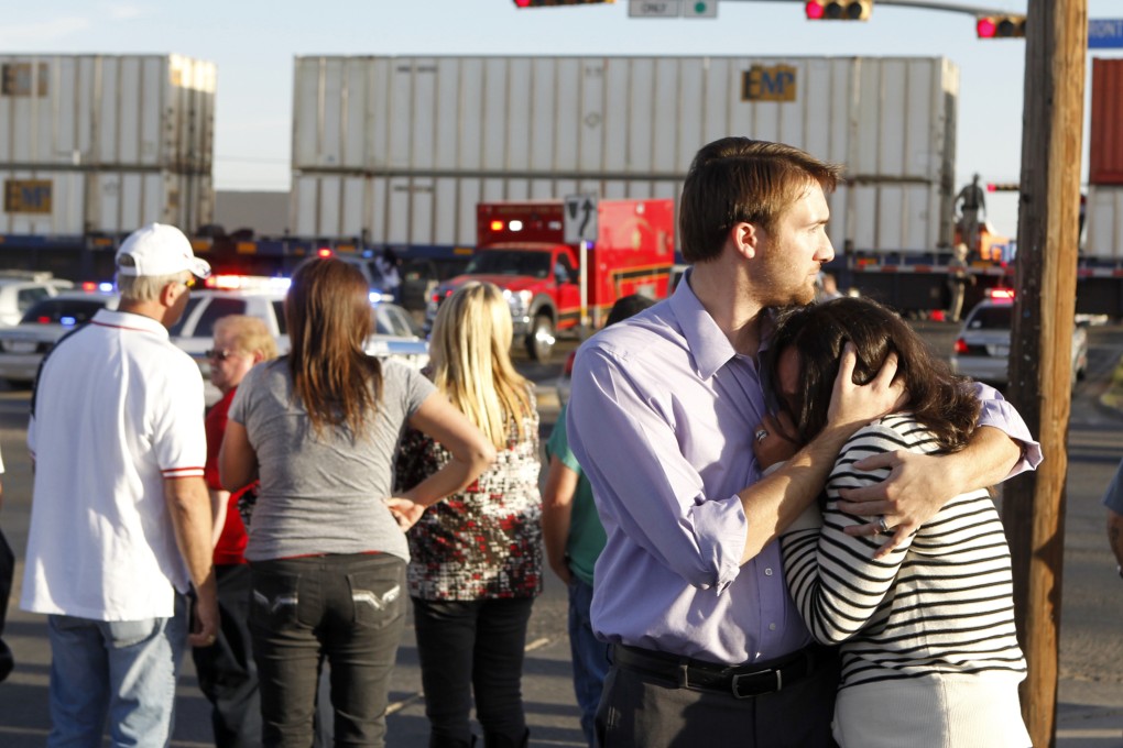 Bystanders comfort each other after a train crashed into a parade float carrying veterans in Midland, Texas, on Thursday. Photo: AP