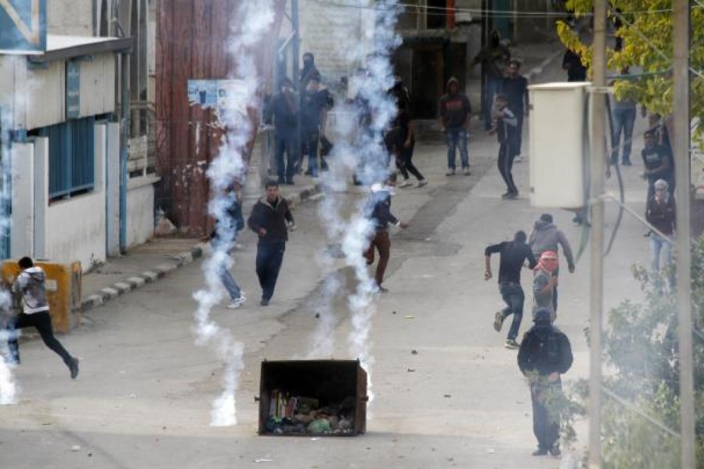 Protesters react to Israeli tear gas in the West Bank. Photo: AFP