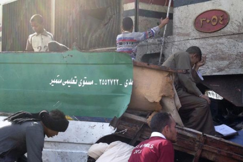 Distraught Egyptians search for signs of their loved ones in the wreckage of a train crash near Assiut in southern Egypt on Saturday. Photo: AP