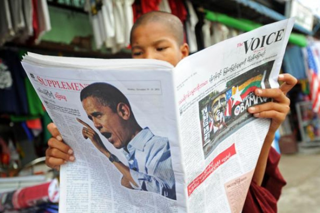 A Buddhist monk reads a local newspaper carrying a picture of US President Barack Obama in Yangon on Saturday. Photo: AFP