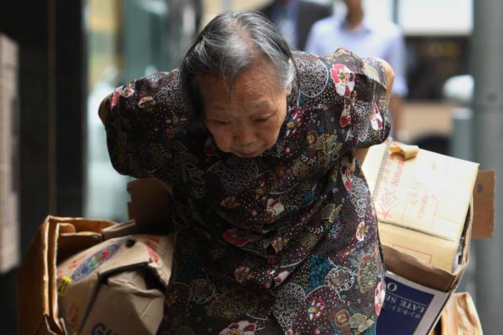 An elderly woman collecting cardboard. Photo: David Wong