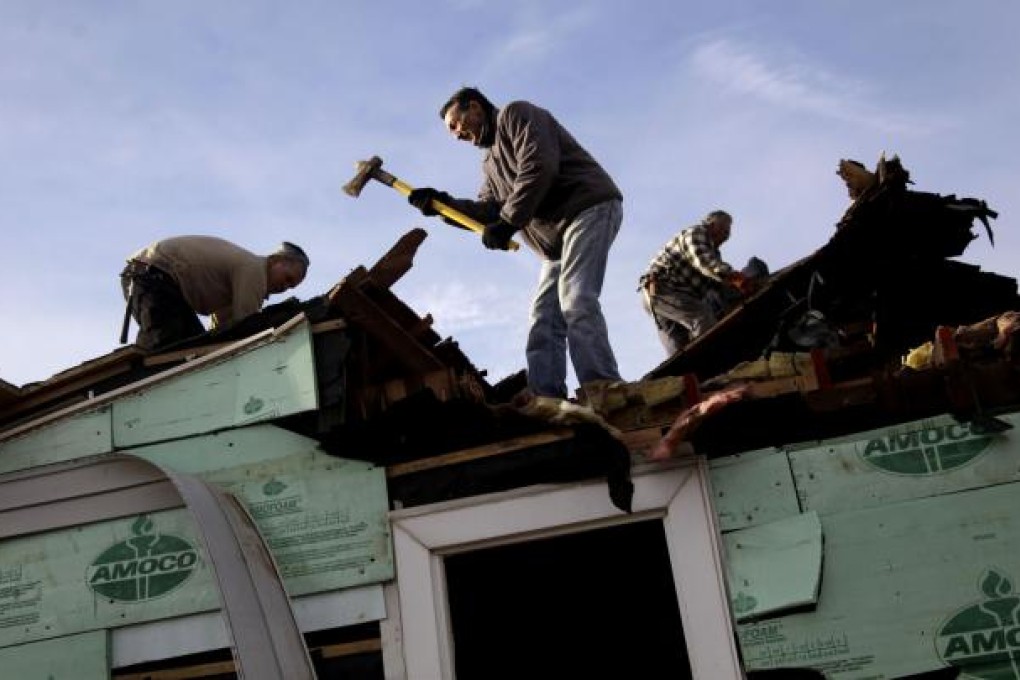 Staten Islander John Toto and friends demolish his Midland Beach home after it was swept off its foundations. The storm also destroyed Toto's beachside restaurant. Photo: AP