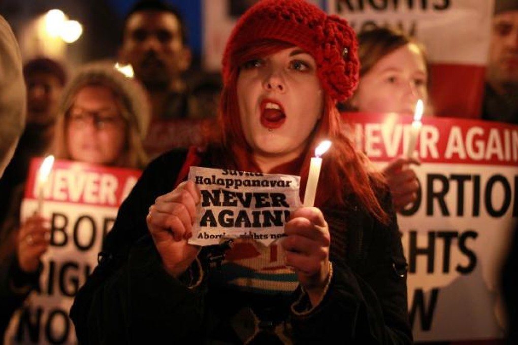 Demonstrators hold placards and candles in memory of Indian Savita Halappanavar who died after being refused an abortion. Photo:AFP