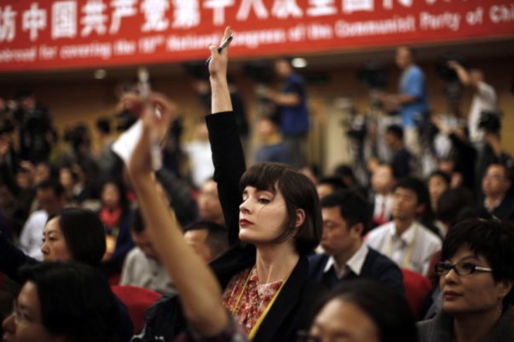 A foreign journalist raises her hand to ask a question during a news conference at the 18th National Party Congress. Photo: Reuters