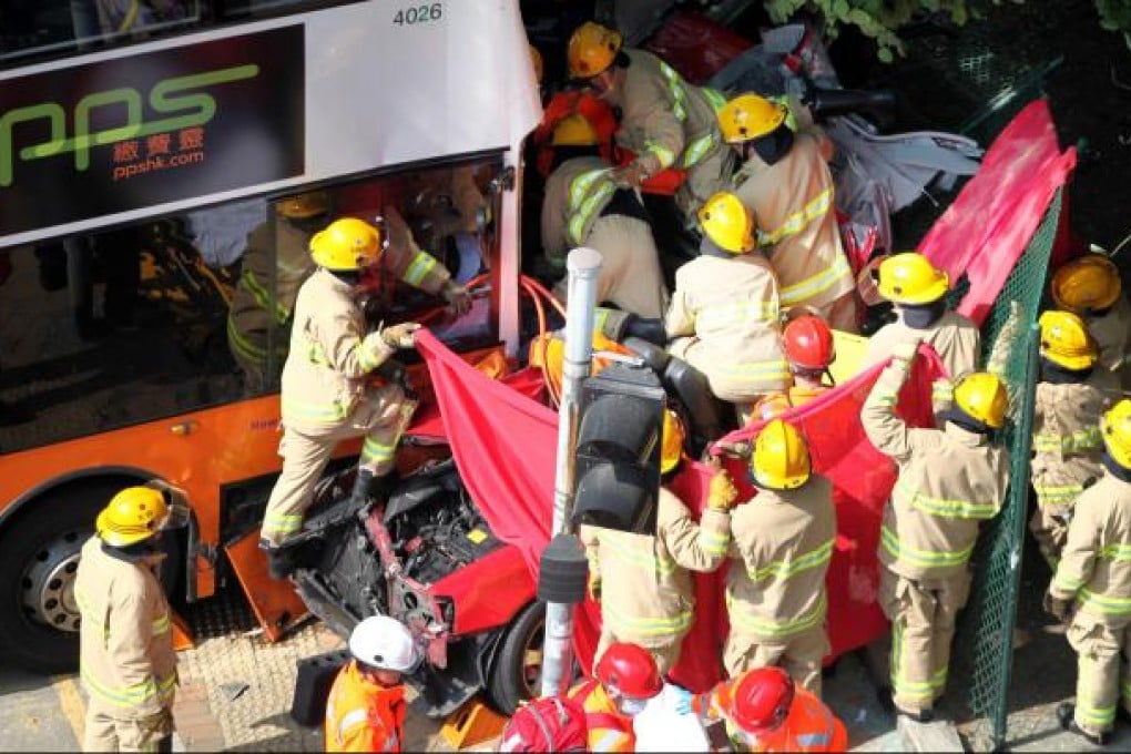 Firefighters and paramedics struggle to free the occupants of the taxi crushed between two buses in yesterday’s fatal crash near Shau Kei Wan. Photo: Thomas Yau