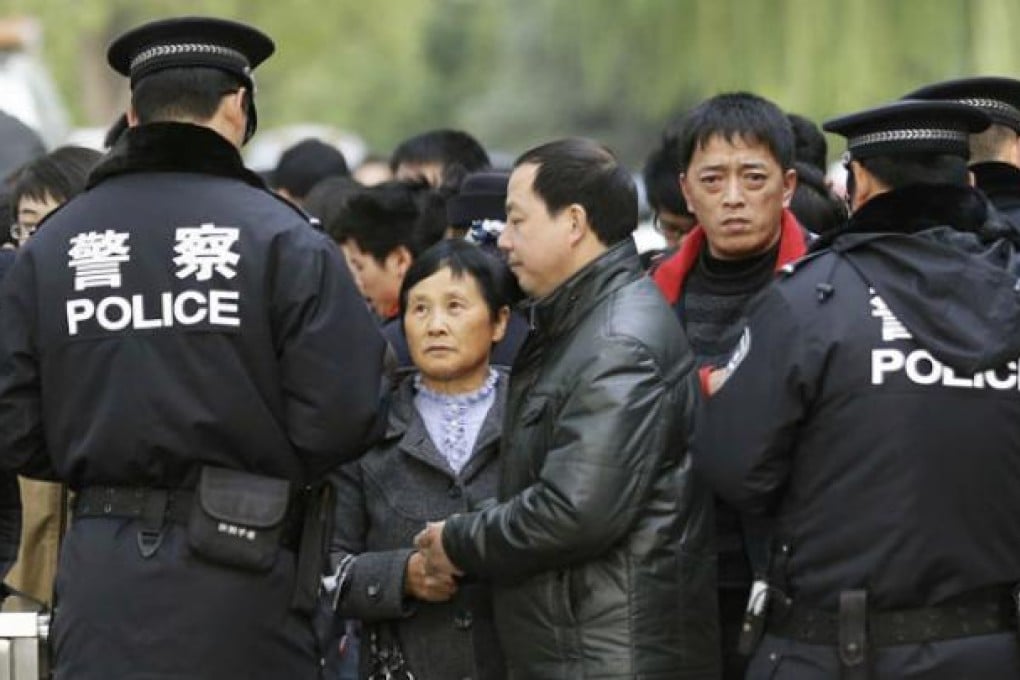 Police check the identity cards of onlookers near Tiananmen Square before the start of the party''s 18th national congress today. Photo: AP