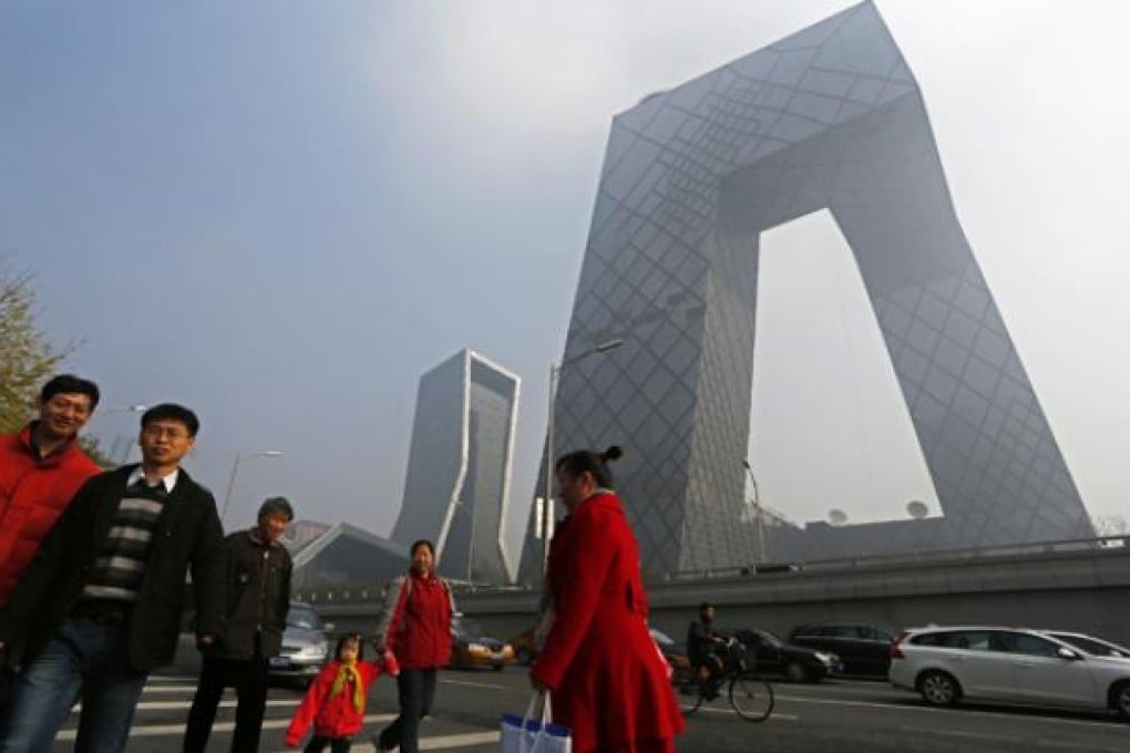 Residents walk past the iconic CCTV building in Beijing. Photo: AP