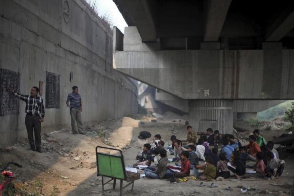 Classes in session at a free school for impoverished slum children run under a metro bridge in New Delhi, India. Photo: AFP