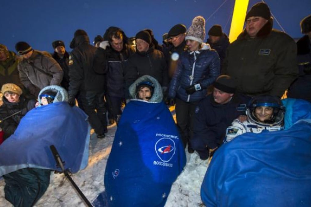 Expedition 33 Commander Sunita Williams (right) and Flight Engineers Yuri Malenchenko and Akihiko Hoshide (left) sit in chairs outside the Soyuz Capsule just minutes after landing on Monday. Photo: AFP/Nasa/Bill Ingalls