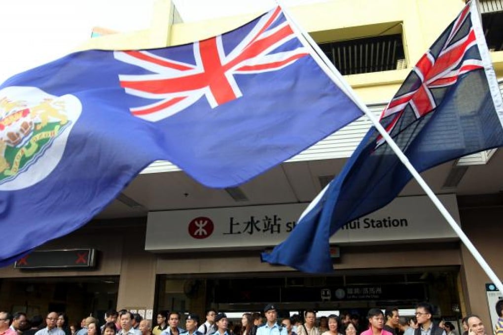 Protestors of Reclaim Sheung Shui wave Hong Kong Colonial Flags outside Sheung Shui MTR station.