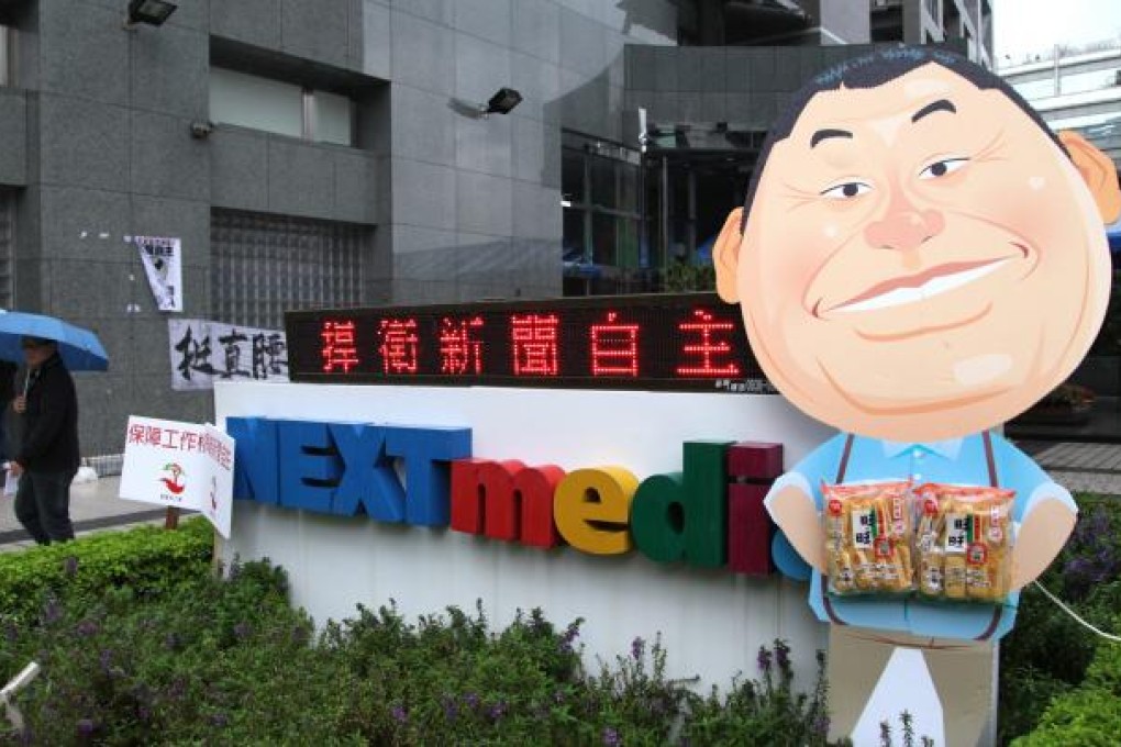 Reporters for NEXT Media's Apple Daily newspaper place a caricature of Hong Kong media mogul and owner of NEXT Media Jimmy Lai , outside NEXT Media's Taiwan headquarters in Taipei. Photo: EPA