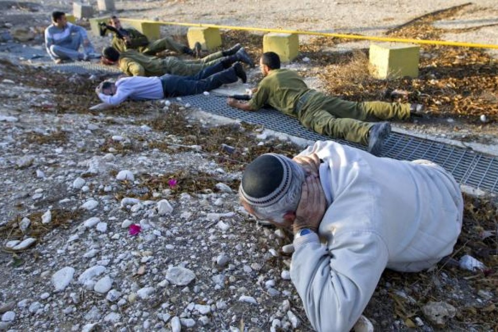 An Israeli man drops to the ground after hearing a Palestinian rocket siren. Photo: EPA