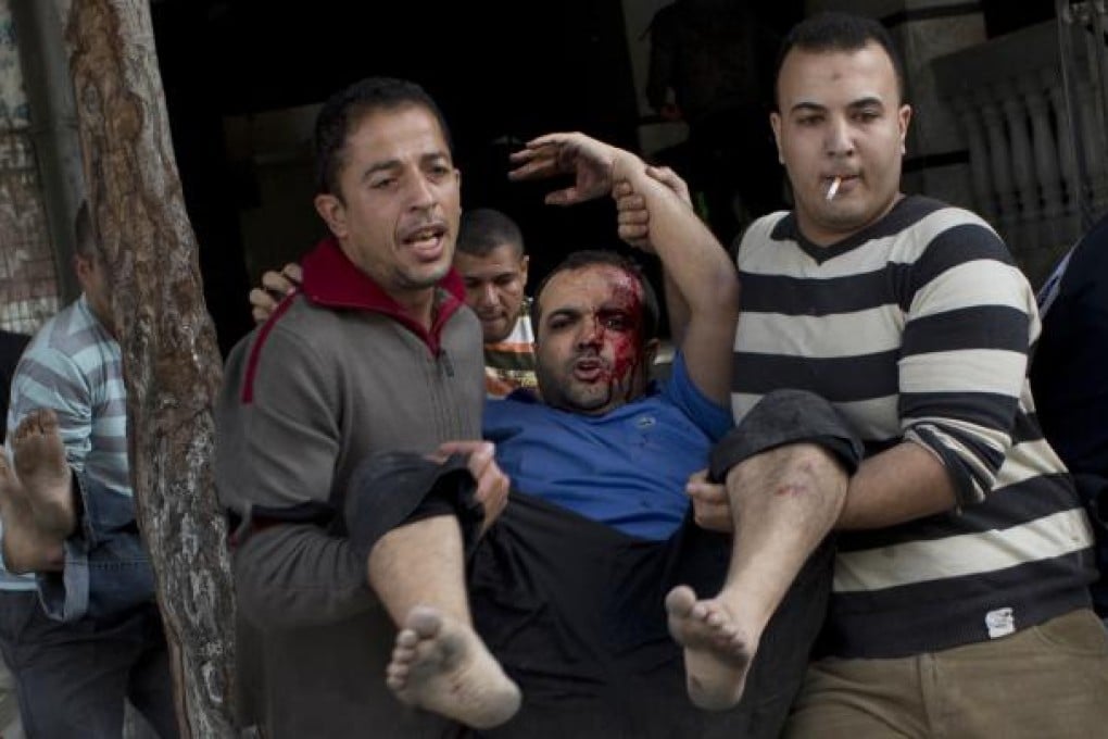 Palestinians carry injured people out of a media center in Gaza City that was hit by an Israeli strike for the second time in two days. Photo: AP