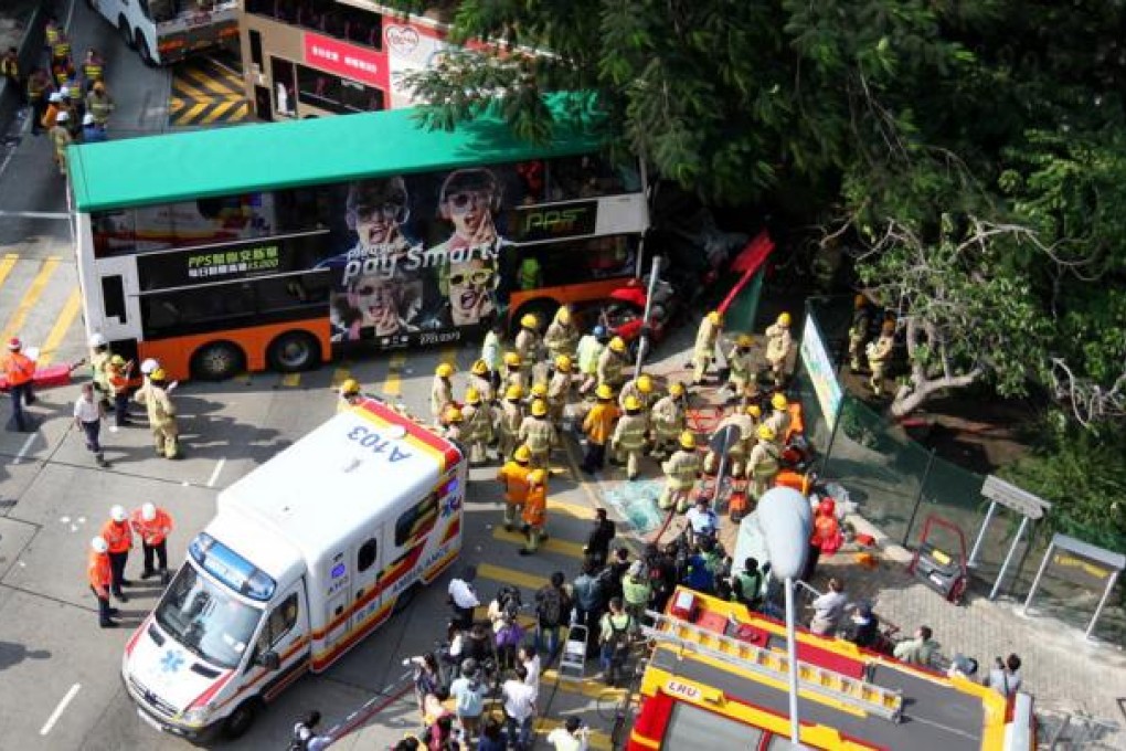 Firefighters remove the bodies from a taxi crushed between two buses. Photo: Thomas Yau