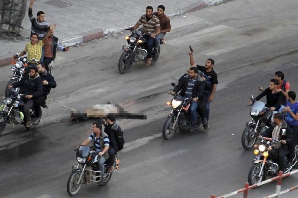 A body is dragged through the streets of Gaza City. The dead man had been a suspected collaborator with Israel. Photo: Reuters