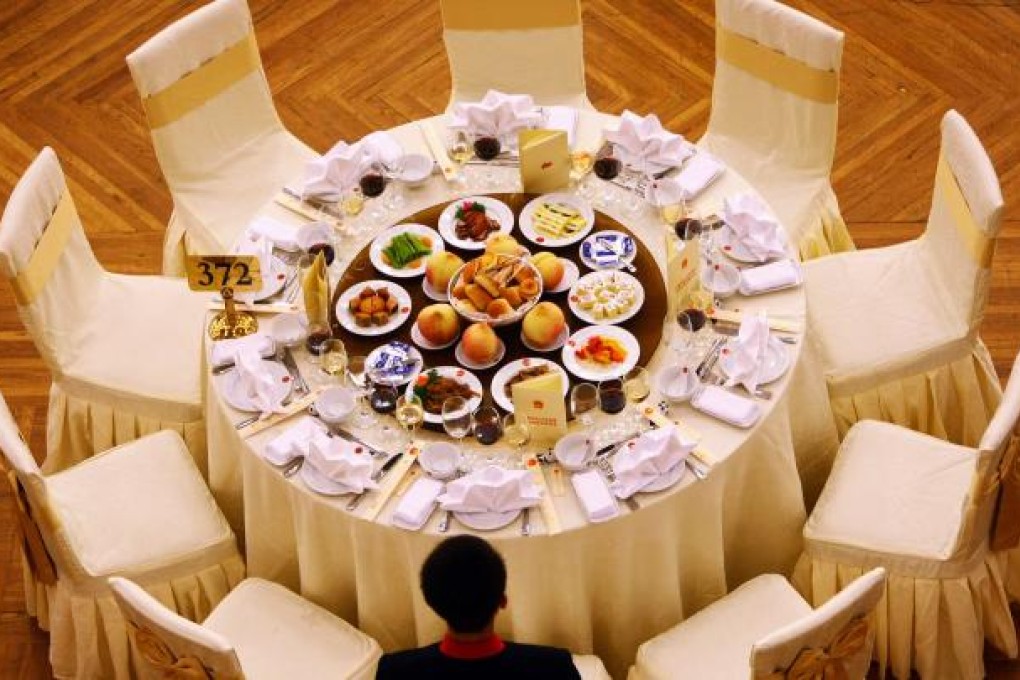 A waiter stands next to a table prepared for an official banquet at the Great Hall of the People in Beijing on Sept. 30, 2009. Photo: AFP