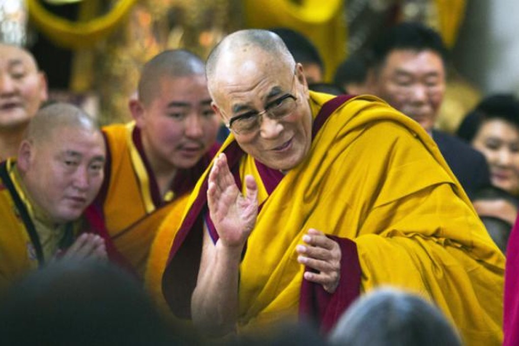Tibetan spiritual leader the Dalai Lama greets devotees as he arrives to give a religious talk at the Tsuglakhang temple in Dharmsala, India, on Tuesday. Photo: AP