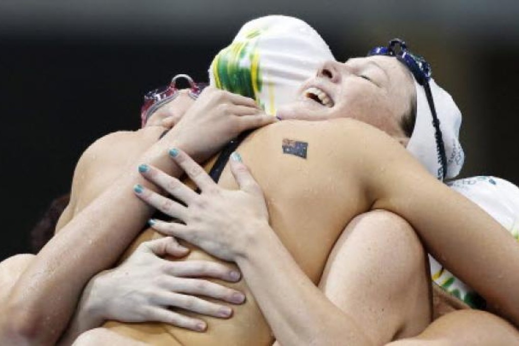 Members of the Australian women’s relay team celebrate after winning the country’s only gold medal in the pool at the London Olympics. Photo: EPA
